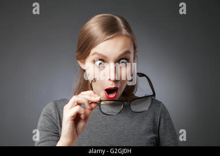 Surprised woman with red lips looking at her glasses Stock Photo