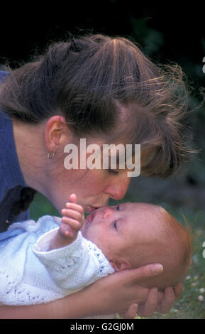 mother kissing newborn baby with Downs Syndrome Stock Photo