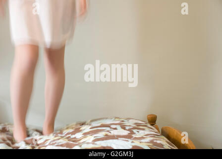 Girl Jumping on Bed Stock Photo