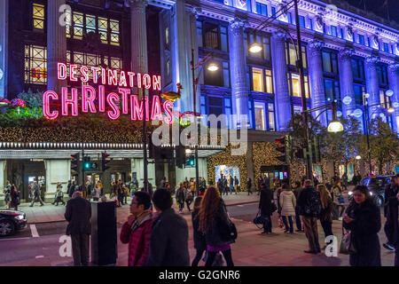 Neon 'Destination Christmas' sign above the main entrance to Selfridges department store on London's Oxford St,  busy with Christmas shoppers, London Stock Photo