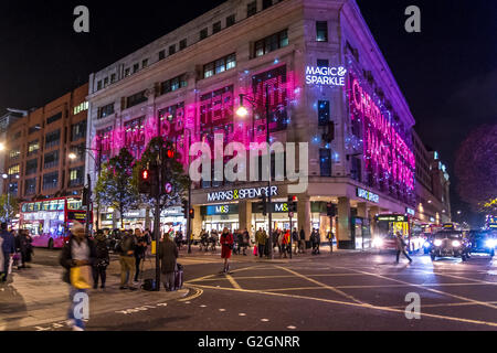 Crowds of Christmas shoppers outside The flagship Marks & Spencer store in London's West End  at Christmas on a packed  Oxford St , London Stock Photo