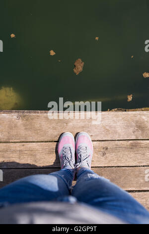 Feet of young woman standing on pier, Lake Plivska jezera Stock Photo