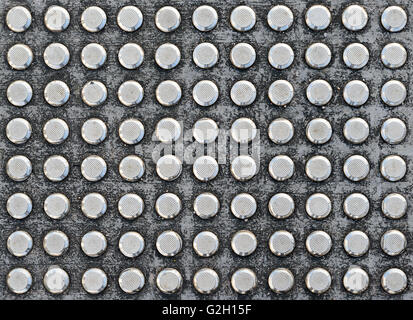 Studs tactile paving textured surface for blind or visually impaired people at a pedestrian crossing Stock Photo