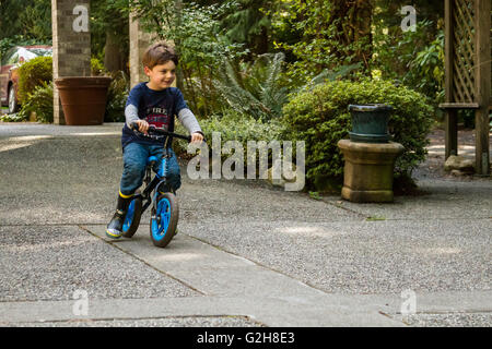 Four year old boy showing off how well he can ride his bike in Issaquah, Washington, USA Stock Photo