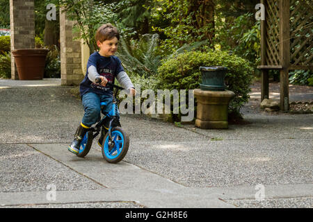 Four year old boy showing off how well he can ride his bike in Issaquah, Washington, USA Stock Photo