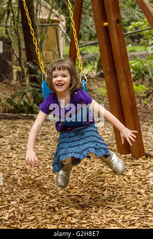 Four year old girl playing on a backyard swing in Issaquah, Washington, USA Stock Photo