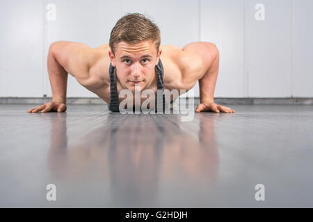 Young man performing push ups at the gym Stock Photo