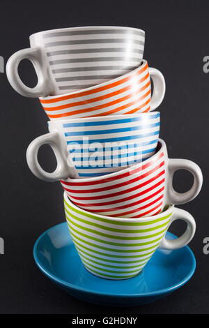 Four tea cups stacked on black background Stock Photo