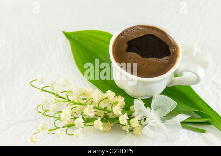 Cup of coffee and lily of the valley flowers Stock Photo