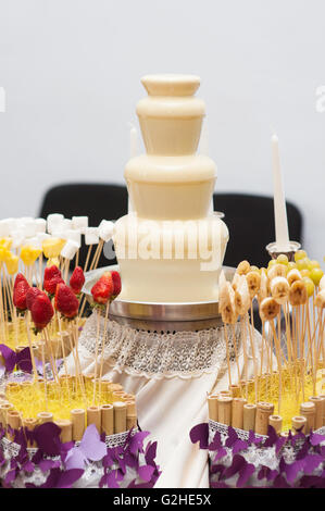 fondue fountain of white chocolate being dipped Stock Photo