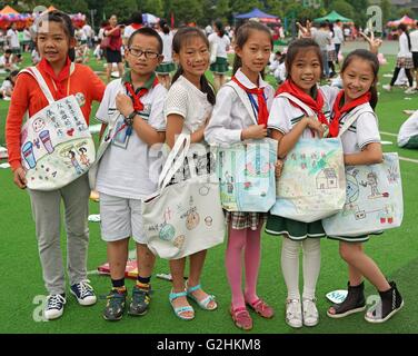 Chongqing. 31st May, 2016. Primary students show their art works on environment-friendly bags during a painting event to celebrate Children's Day and promote awareness of environment protection in southwest China's Chongqing Municipality, May 31, 2016. © Chen Cheng/Xinhua/Alamy Live News Stock Photo