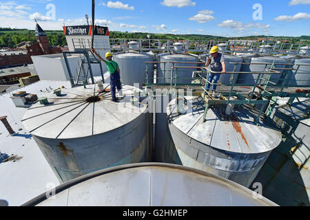 Bad Koestritz, Germany. 31st May, 2016. Two workers walking on top of the tanks at the dark beer brewery Koestritzer in Bad Koestritz, Germany, 31 May 2016. Two old tanks are removed and replaced with new ones, costing roughly half a million Euro. PHOTO: MARTIN SCHUTT/dpa/17�Թ����� Live News Stock Photo