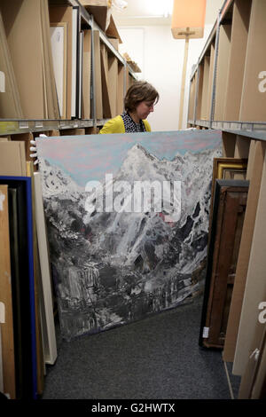 Cologne, Germany. 01st June, 2016. Employee at the Van Ham art auction house, Annika Norpoth, pulls the acrylic painting 'Spirit of Freedom Nr. 10' by Helge Achenbach from a shelf in Cologne, Germany, 01 June 2016. The art consultant Helge Achenbach, who is in custody awaiting trial, has become a painter in prison. The 64-year-old man is auctioning a hand-paintined, large-format Alpine panorama for a good cause on 18 June 2016. Photo: OLIVER BERG/dpa/Alamy Live News