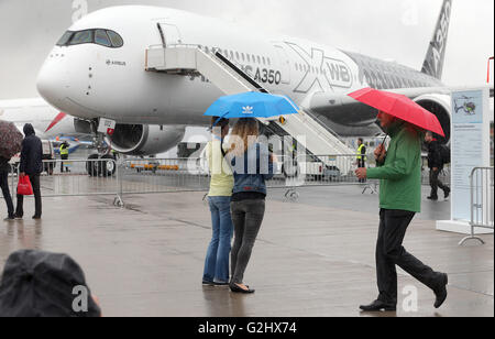 Schoenefeld, Germany. 01st June, 2016. Visitors to the fair walk across the fairgrounds in heavy rainfall at the Berlin Air Show (ILA) in Schoenefeld, Germany, 01 June 2016. The air show at Berlin-Schoenefeld Airport is open from 01 to 04 June 2016. Photo: WOLFGANG KUMM/dpa/Alamy Live News Stock Photo