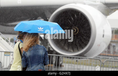 Schoenefeld, Germany. 01st June, 2016. Visitors to the fair walk across the fairgrounds in heavy rainfall at the Berlin Air Show (ILA) in Schoenefeld, Germany, 01 June 2016. The air show at Berlin-Schoenefeld Airport is open from 01 to 04 June 2016. Photo: WOLFGANG KUMM/dpa/Alamy Live News Stock Photo