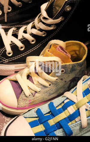 Converse shoes on display. They are an American shoe company that designs and produces sneakers that are cool grungy popular with the youth culture Stock Photo Alamy