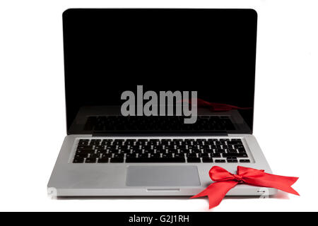 Silver Laptop with blank black screen and red bow on the keyboard isolated on white background Stock Photo