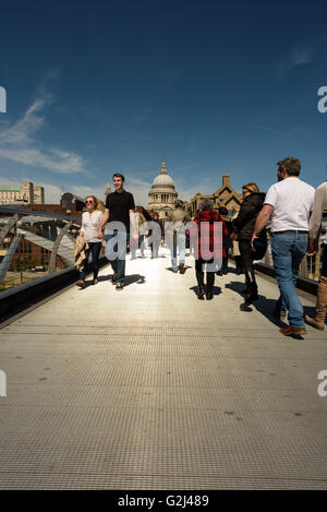 Tourists walking across the famous Millennium bridge in London on May Day Bank Holiday in sunshine