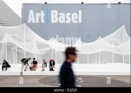 Basel, Switzerland - June 17, 2014: Exhibition hall of Art Basel 2014, one of the world's largest and most spectacular modern art gatherings in Basel, Switzerland. In 2013 the show attracted 70000 visitors over six show day. Art installation in front if the building: Zerzura by Panterapantera. Stock Photo