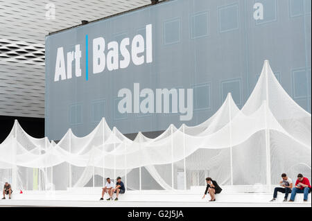 Basel, Switzerland - June 17, 2014: Exhibition hall of Art Basel 2014, one of the world's largest and most spectacular modern art gatherings in Basel, Switzerland. In 2013 the show attracted 70000 visitors over six show day. Art installation in front if the building: Zerzura by Panterapantera. Stock Photo