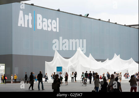 Basel, Switzerland - June 17, 2014: Exhibition hall of Art Basel 2014, one of the world's largest and most spectacular modern art gatherings in Basel, Switzerland. In 2013 the show attracted 70000 visitors over six show day. Art installation in front if the building: Zerzura by Panterapantera. Stock Photo