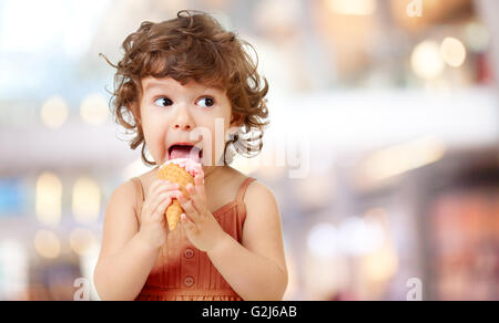 Kid eating ice cream. Funy curly child with icecream. Stock Photo