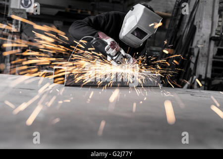 Heavy industry worker grinding with mask on the face Stock Photo
