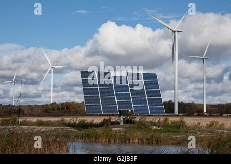 Solar panels on tracking system and windmills in farmland of southwestern Ontario (near Lake Erie), Ontario, Canada. Stock Photo
