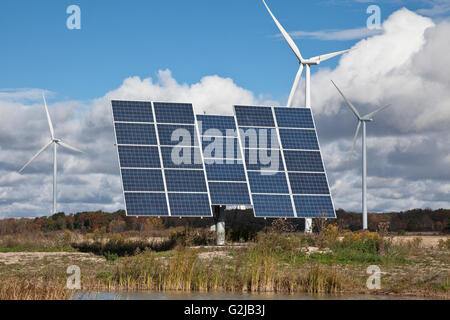 Solar panels on tracking system and windmills in farmland of southwestern Ontario (near Lake Erie), Ontario, Canada. Stock Photo