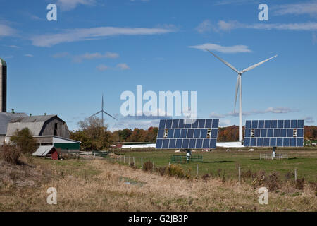 Solar panels on tracking system and windmills in farmland of southwestern Ontario (near Lake Erie), Ontario, Canada. Stock Photo