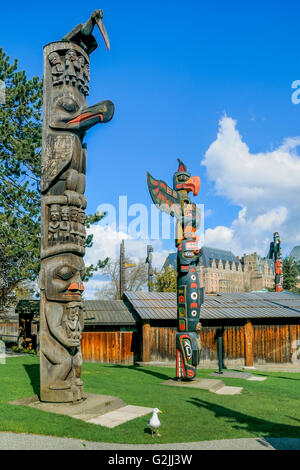 First Nation Totem poles, Thunderbird Park, beside Royal British Columbia Museum, with Empress Hotel in background, Victoria,  B Stock Photo