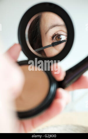 Woman applying make-up Stock Photo