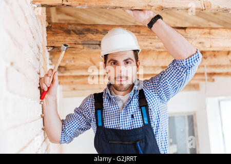 Close-up portrait of a handsome young builder holding a hammer Stock Photo