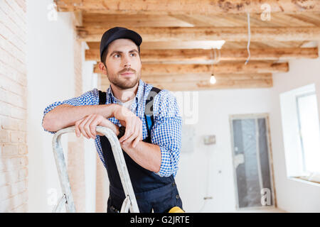 Handsome construction builder thinking about something while working indoors Stock Photo