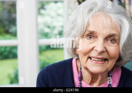 Head And Shoulders Portrait Of Smiling Senior Woman At Home Stock Photo