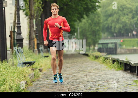 Young running man in the city. Caucasian Cheerfull jogger male in his 20s Stock Photo
