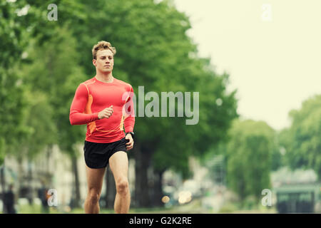 Young running man in the city. Caucasian Cheerfull jogger male in his 20s Stock Photo