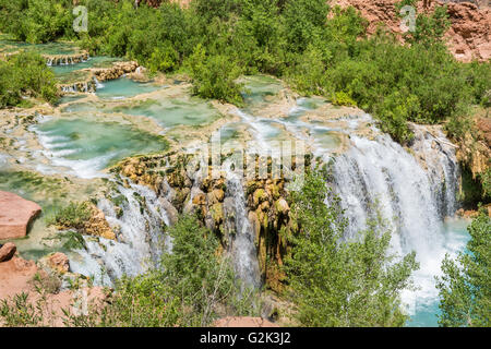 Water from Havasu Creek flows over travertine pools and rushes over Little Navajo Falls on the Havasupai Indian Reservation. Stock Photo