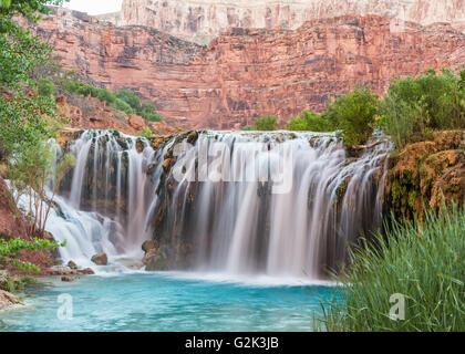 Silky water flows over Little Navajo Falls into a turquoise pool on the Havasupai Indian Reservation in the Grand Canyon. Stock Photo