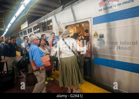 Thousands pack the Cannonball at Penn Station in New York to get out of the city for the Memorial Day weekend on Friday, May 27, 2016. Every Friday during the summer the train, consisting of double-decker cars pulled by a powerful dual-mode locomotive, will run express to Westhampton on Long Island making the 76 mile trip in 94 minutes. From Westhampton it will continue to points east arriving at the tip of the island, Montauk. On Sundays the train will reverse and return to Penn Station. The train is the only named run on the railroad. The trip from Penn Station to the Montauk terminal is 117 Stock Photo