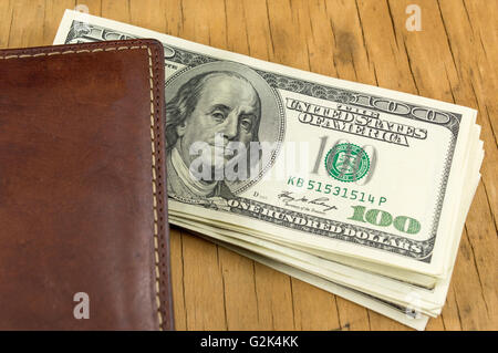 Leather wallet with dollar bills falling out Stock Photo