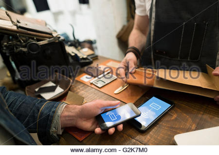 Customer using contactless payment in leather shop