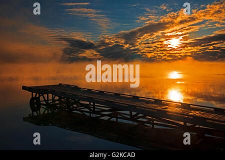Dock in fog at sunrise on Sturgeon Lake Williamson Provincial Park Alberta Canada Stock Photo