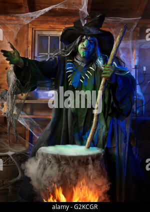 Scary old witch stirring potion in a cauldron inside her cabin on ...