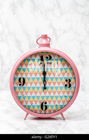 Pink retro alarm clock on white marble background Stock Photo