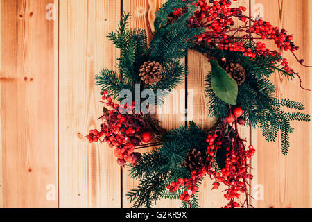 Beautiful wreath hanging on wooden door. Stock Photo