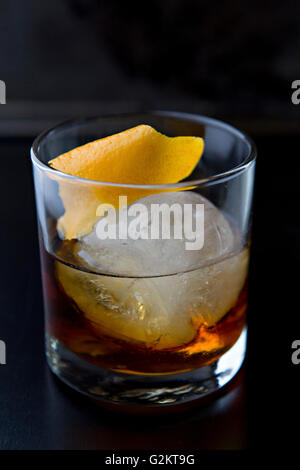 https://l450v.alamy.com/450v/g2kt9g/whiskey-in-glass-with-large-ice-cube-and-orange-garnish-g2kt9g.jpg