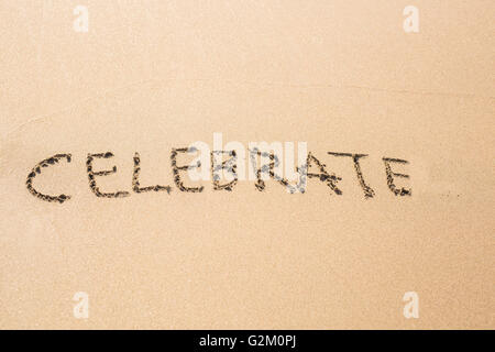 celebrate word handwritten on a sand of beach Stock Photo