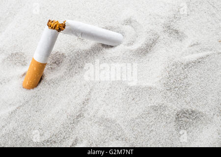 Quit Smoking - Broken unsmoked cigarette in sand with copyspace Stock Photo