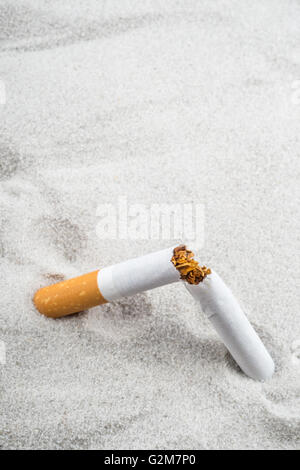 Quit Smoking - Broken unsmoked cigarette in sand with copyspace Stock Photo